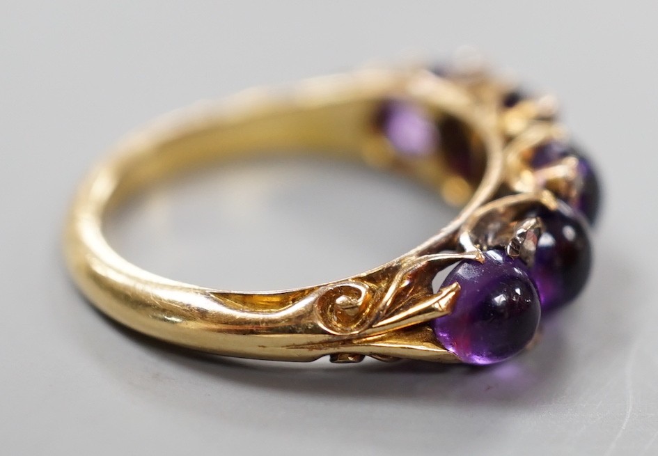 A late Victorian yellow metal and five stone graduated cabochon amethyst set half hoop ring, with rose cut diamond chip spacers, size M, gross weight 4.7 grams.